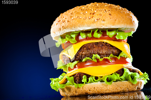 Image of Tasty and appetizing hamburger on a dark blue