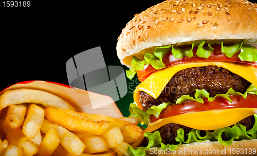 Image of Tasty hamburger and french fries on a dark