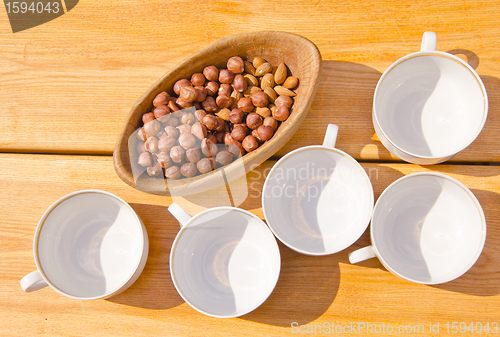 Image of hazelnuts pack in wooden dish cups placed on table 