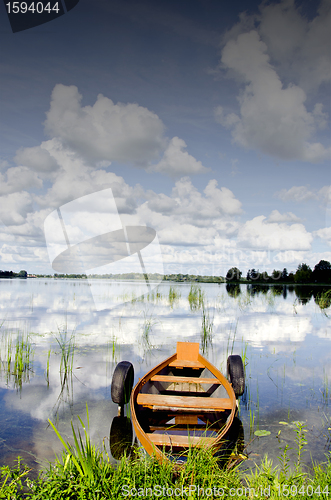 Image of Boat moored rubber tires cloud reflection on water 