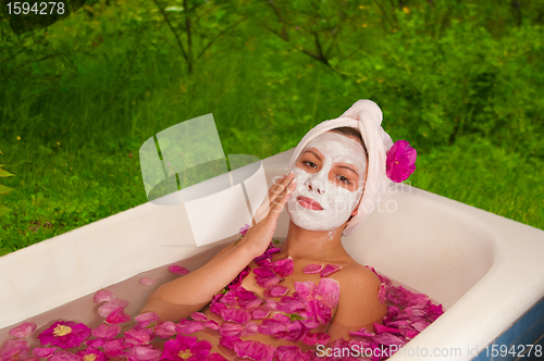 Image of beautiful woman enjoying floral bath