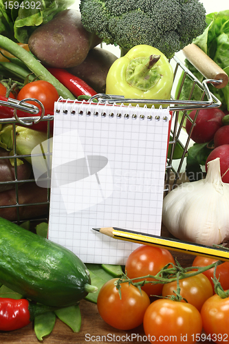 Image of shopping list with pencil, basket and vegetables