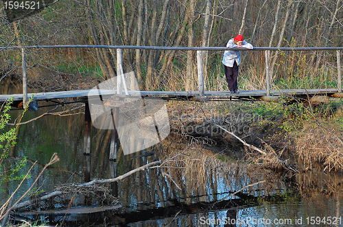 Image of Sad Woman on Wooden Bridge in the Late Fall