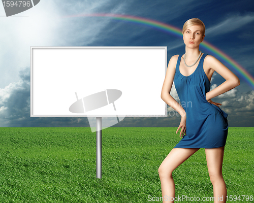 Image of billboard and sexy blonde on green grass and blue cloudly sky