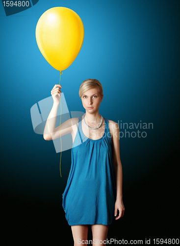 Image of blonde in blue dress with the yellow balloon