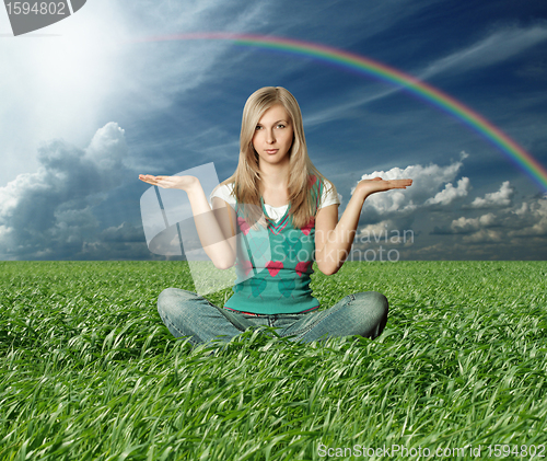 Image of Blonde in lotus pose in green grass