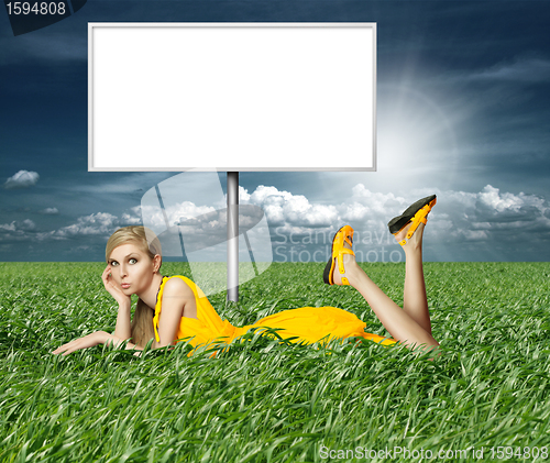 Image of Blonde in yellow dress in green grass