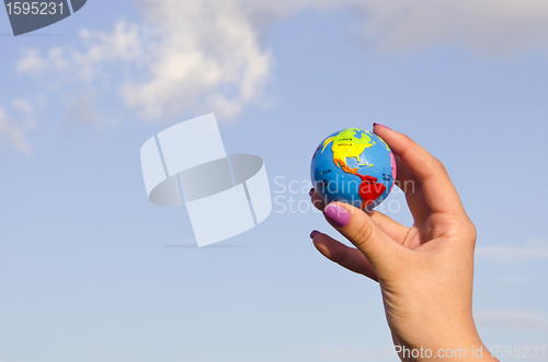 Image of Hand holding globe.