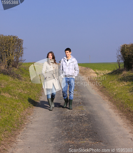 Image of Couple of young people walking in the campaign in spring