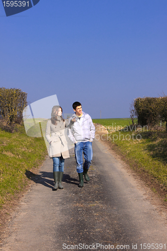 Image of Couple of young people walking in the campaign in spring