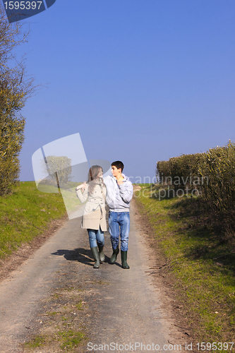 Image of Couple of young people walking in the campaign in spring