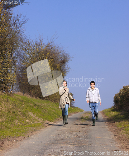 Image of Couple of young people walking in the campaign in spring