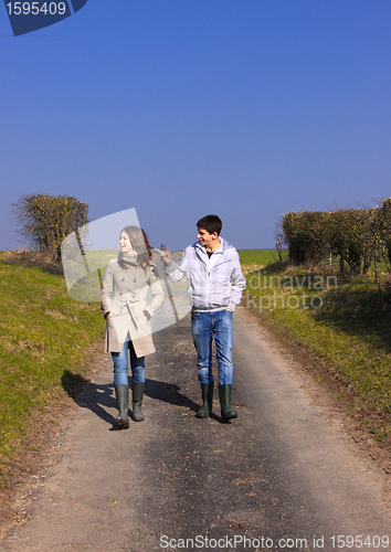 Image of Couple of young people walking in the campaign in spring