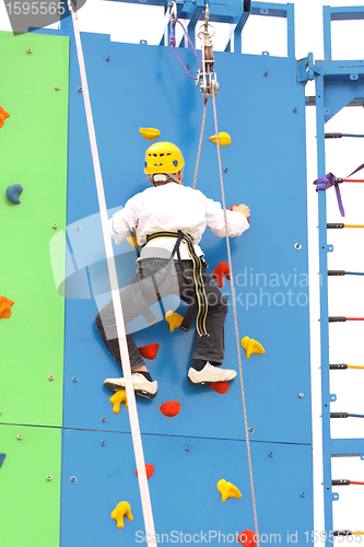 Image of Child climbing on a climbing wall, outdoor