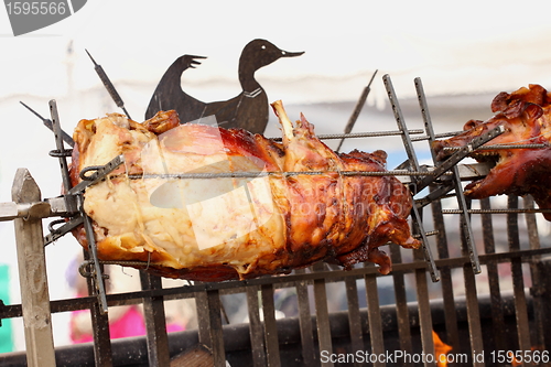Image of pig on a spit. Spit roasting is a traditional international method of cooking a whole pig. 
