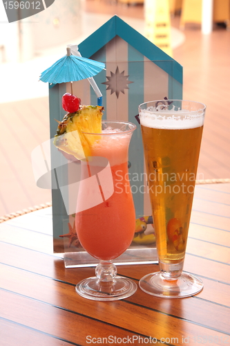 Image of glass of fruit cocktail and a glass of beer