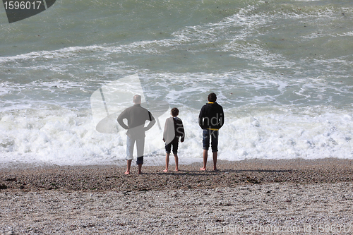Image of a father and his two boys watching the sea