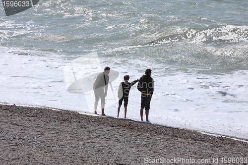 Image of a father and his two boys watching the sea