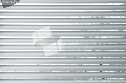 Image of Semi-closed metallic blinds on a window