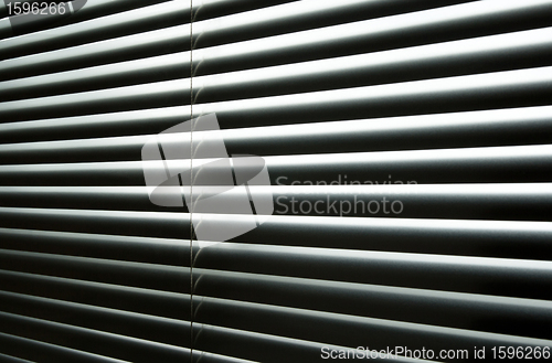 Image of Light coming through closed metallic blinds