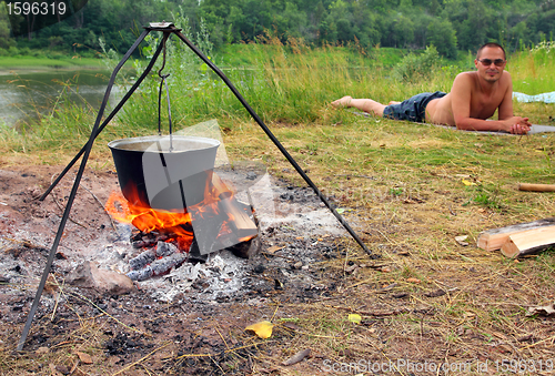 Image of camping - kettle and lying tourist