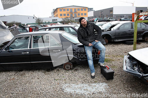 Image of man looking at the scrap yard car parts