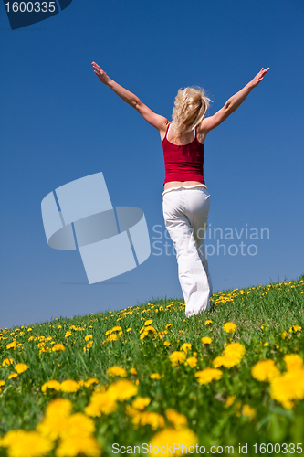 Image of young woman in red outfit having fun on meadow