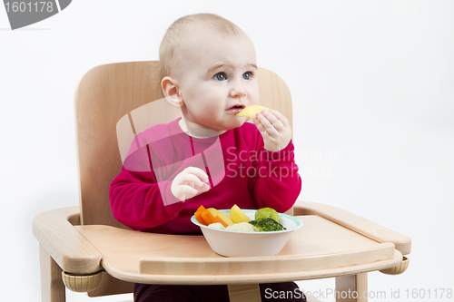 Image of young child eating in high chair