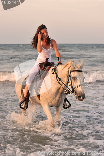 Image of woman and  horse in the sea