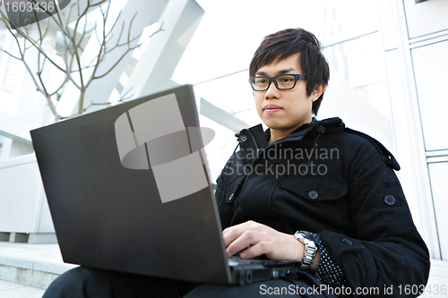 Image of man using computer outdoor