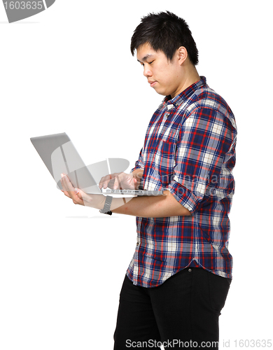 Image of Young asian man using laptop computer