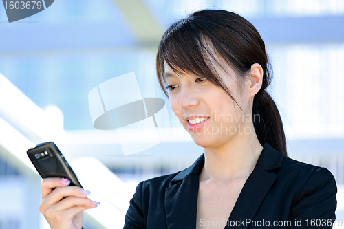Image of Business woman sms message on mobile phone