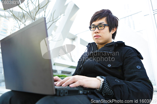 Image of man using computer outdoor