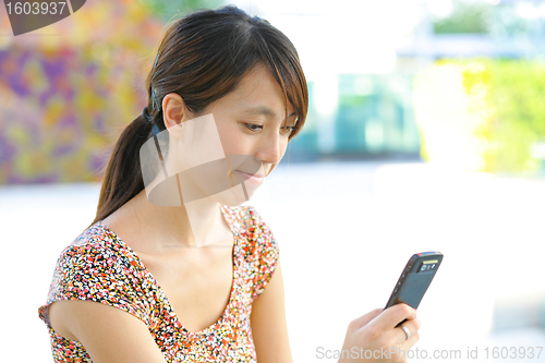 Image of woman sms on mobile phone