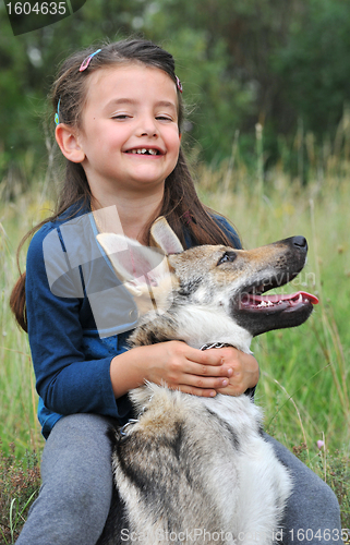 Image of little girl and her baby wolf dog