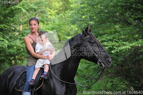 Image of mother, son and black horse