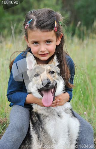 Image of little girl and her baby wolf dog