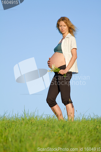 Image of pregnant woman on meadow