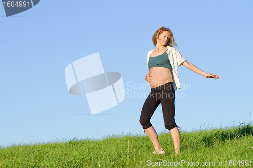 Image of pregnant woman on meadow