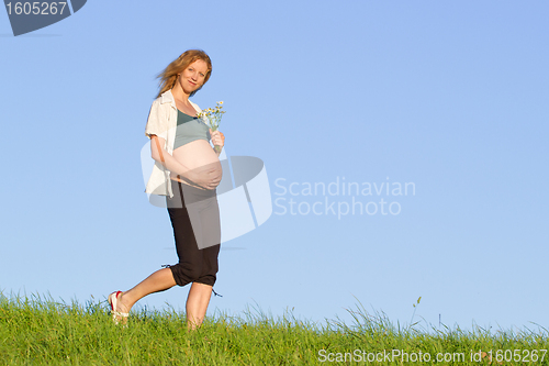 Image of pregnant woman on meadow