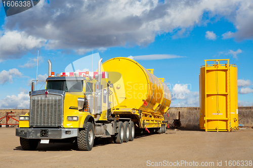 Image of Yellow Transport With Oilfield Tanks