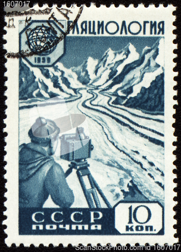 Image of Researcher with device in mountain on post stamp