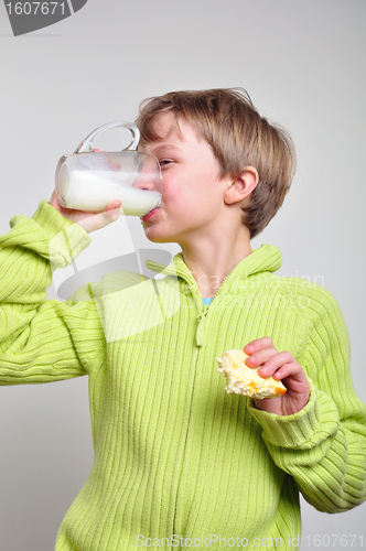 Image of child boy eating cake and drinking milk