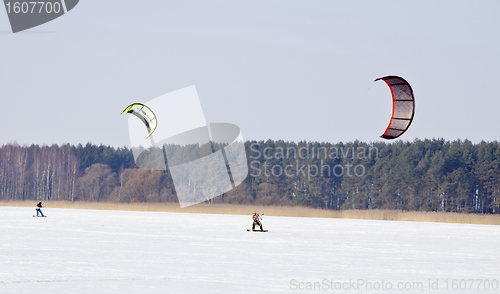Image of Kiteboarding with snowboards frozen lake in winter 