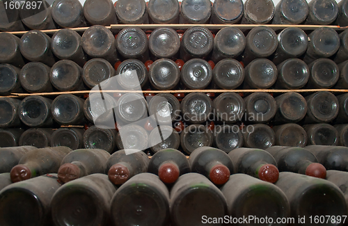 Image of Red wine bottles in a cellar