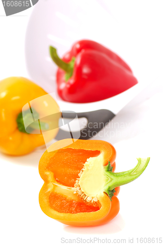 Image of Orange, yellow and red bell peppers with a strainer