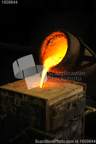 Image of Foundry - molten metal poured from ladle into mould - lost wax casting