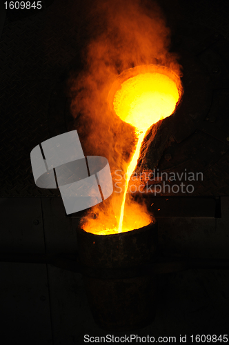 Image of Foundry - molten metal poured from ladle for casting