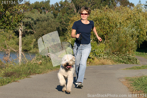 Image of Woman running with her dog