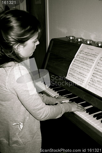 Image of Young girl is playing classic piano